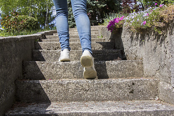 Image showing Young woman climbs on concrete stairs