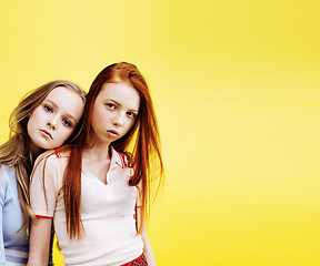 Image showing lifestyle people concept: two pretty young school teenage girls having fun happy smiling on yellow background 