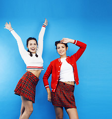 Image showing best friends teenage school girls together having fun, posing emotional on blue background, besties happy smiling, lifestyle people concept 