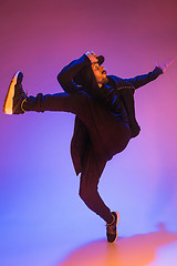 Image showing The silhouette of one hip hop male break dancer dancing on colorful background