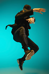 Image showing The silhouette of one hip hop male break dancer dancing on colorful background