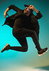 Image showing The silhouette of one hip hop male break dancer dancing on colorful background