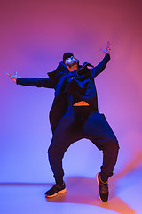 Image showing The silhouette of one hip hop male break dancer dancing on colorful background