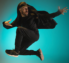 Image showing The silhouette of one hip hop male break dancer dancing on colorful background