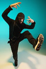 Image showing The silhouette of one hip hop male break dancer dancing on colorful background