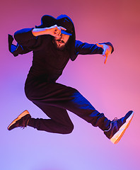 Image showing The silhouette of one hip hop male break dancer dancing on colorful background