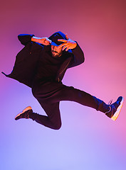 Image showing The silhouette of one hip hop male break dancer dancing on colorful background