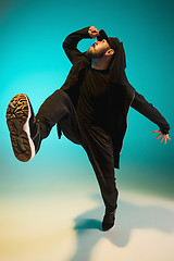 Image showing The silhouette of one hip hop male break dancer dancing on colorful background