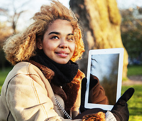 Image showing young cute blond african american girl student holding tablet an