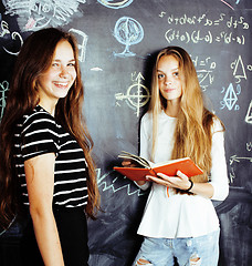 Image showing back to school after summer vacations, two teen real girls in classroom with blackboard painted together, lifestyle people concept