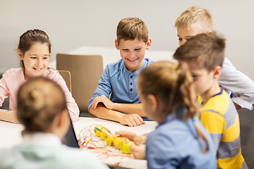 Image showing happy children building robots at robotics school