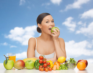 Image showing woman with fruits and vegetables eating apple