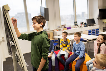 Image showing student boy with marker writing on flip board