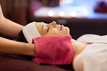 Image showing woman having face massage with terry gloves at spa