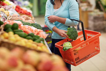 Image showing woman with basket buying broccoli at grocery store