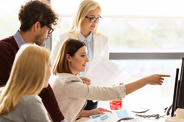 Image showing happy creative team with computer in office