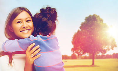 Image showing happy mother and daughter hugging outdoors