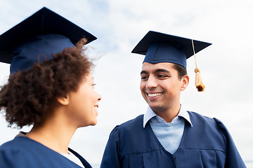 Image showing happy students or bachelors in mortarboards