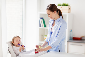 Image showing mother and baby with spoon eating puree at home