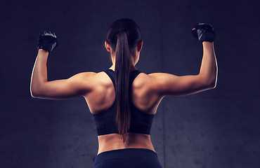 Image showing young woman flexing muscles in gym