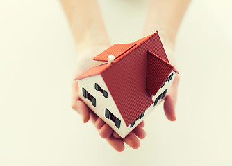 Image showing close up of hands holding house or home model