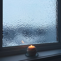 Image showing Frosted window and candle light