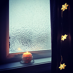 Image showing Cozy frosted window and candle light