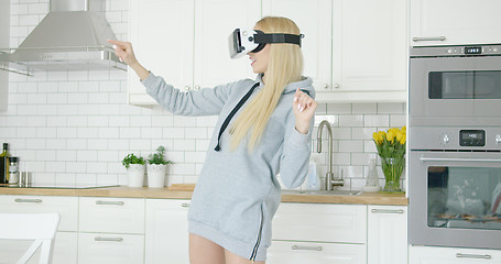 Image showing Woman in VR glasses in kitchen