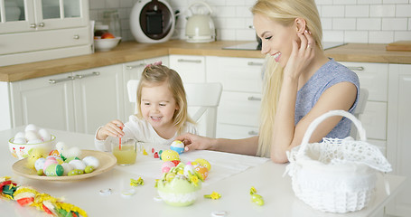 Image showing Laughing woman and little girl coloring eggs