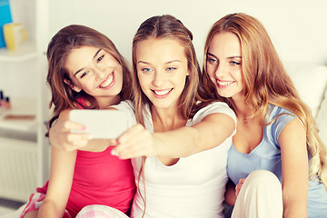 Image showing teen girls with smartphone taking selfie at home