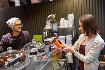 Image showing happy woman buying chai latte drink at vegan cafe