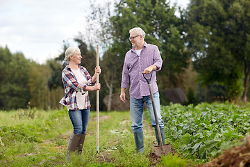 Image showing senior couple with shovels at garden or farm