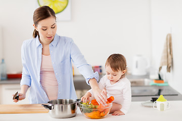 Image showing happy mother and baby cooking food at home kitchen