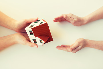 Image showing close up of hands giving house or home model