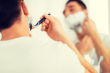 Image showing close up of man shaving beard with razor blade