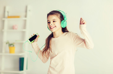 Image showing girl with smartphone and headphones at home