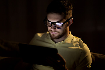 Image showing young man with tablet pc networking at night