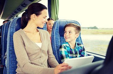 Image showing happy family with tablet pc sitting in travel bus