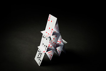 Image showing house of playing cards over black background