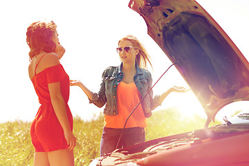 Image showing women with open hood of broken car at countryside