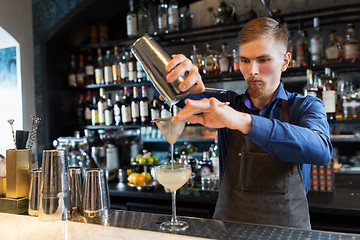 Image showing barman with shaker preparing cocktail at bar