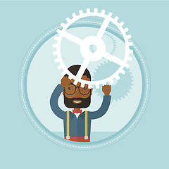 Image showing Businessman holding cogwheel above his head.