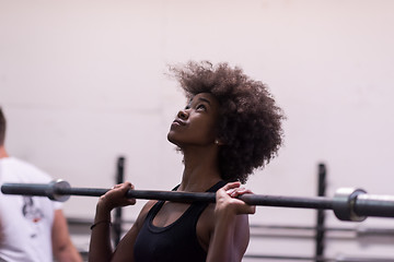 Image showing black woman lifting empty bar