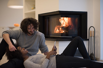 Image showing multiethnic couple using tablet computer on the floor