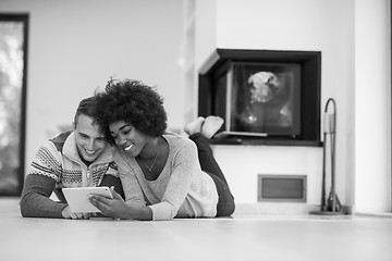 Image showing multiethnic couple used tablet computer on the floor