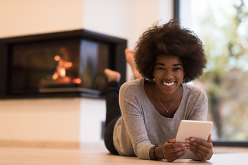 Image showing black women using tablet computer on the floor