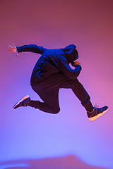 Image showing The silhouette of one hip hop male break dancer dancing on colorful background