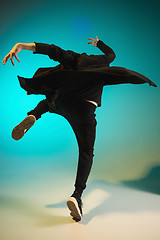 Image showing The silhouette of one hip hop male break dancer dancing on colorful background