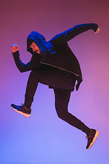 Image showing The silhouette of one hip hop male break dancer dancing on colorful background