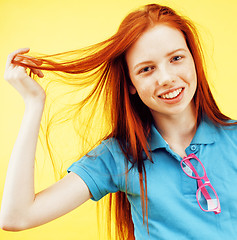 Image showing Beauty and skin care. Highly-detailed portrait of attractive redhead teenage girl with charming smile and cute freckles having rest indoors wearing her hair loose. Beautiful woman relaxing at home on 